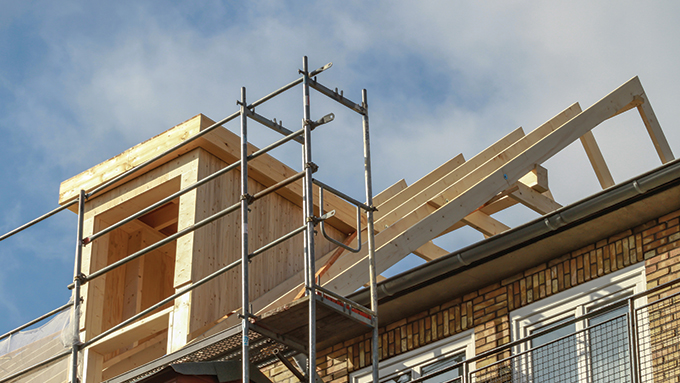 a loft conversion in the process of being built, with the beams in place and scaffolding erected